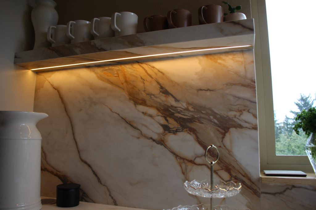 Under-shelf LED lighting recessed into a custom notch on a floating quartz shelf, creating a modern, seamless glow.