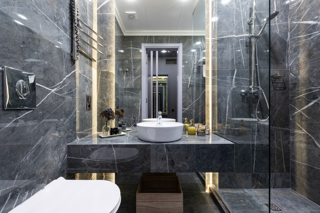 Custom dark marble bathroom with LED backlighting and vessel sink
