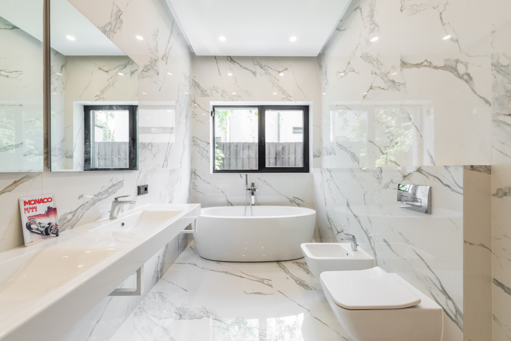 Modern bathroom with marble-look tile, freestanding tub, and double sink vanity
