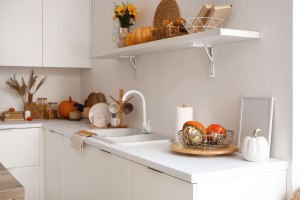 White kitchen counter with pumpkins and autumn decorations