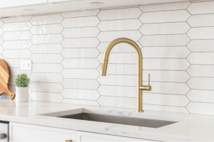 Modern kitchen with gold faucet, quartz countertop, and white tile backsplash